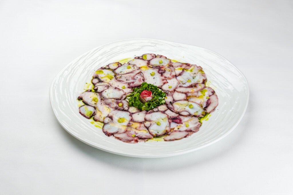 Octopus carpaccio with herbs and olive oil - raw seafood crudo at Pietra